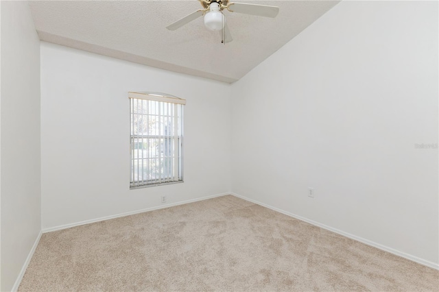 empty room featuring a ceiling fan, a textured ceiling, baseboards, carpet flooring, and lofted ceiling