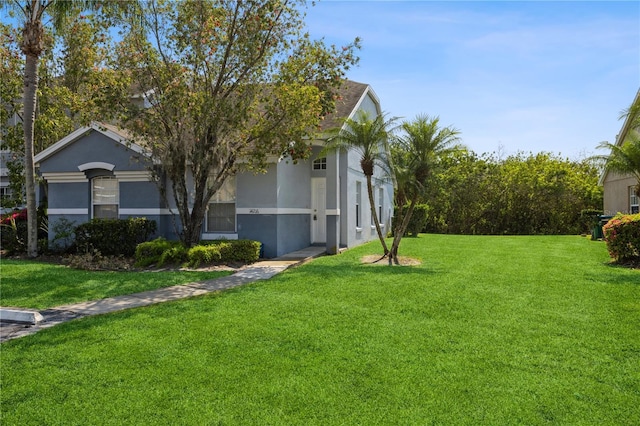 view of property exterior with stucco siding and a yard