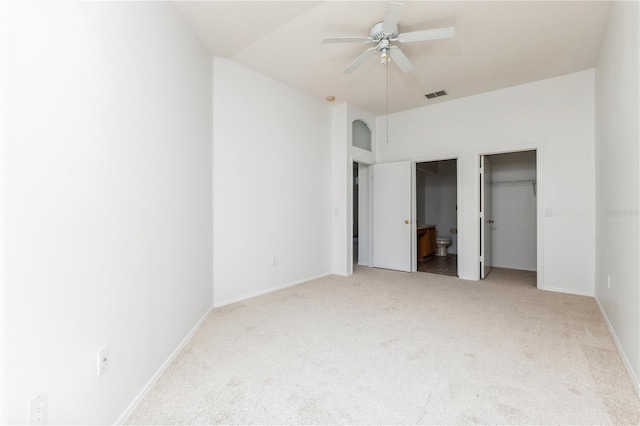 unfurnished bedroom with visible vents, ensuite bath, carpet, baseboards, and ceiling fan