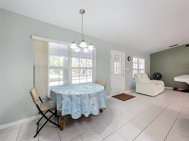 tiled dining area featuring a chandelier