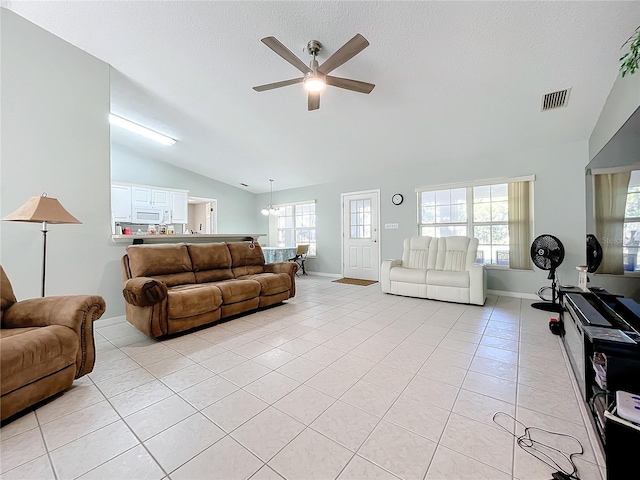 tiled living room featuring ceiling fan and vaulted ceiling