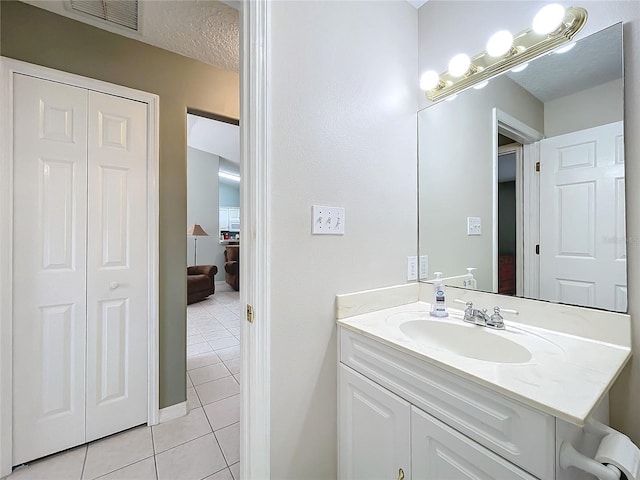 bathroom featuring tile patterned flooring, vanity, and a textured ceiling