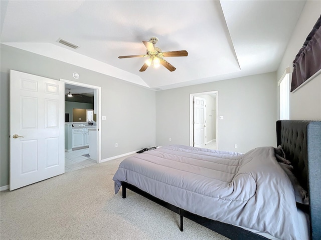 carpeted bedroom featuring connected bathroom, a raised ceiling, and ceiling fan