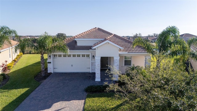 mediterranean / spanish home featuring a front yard and a garage