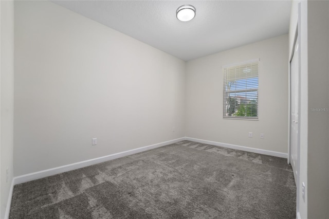 unfurnished bedroom with dark carpet