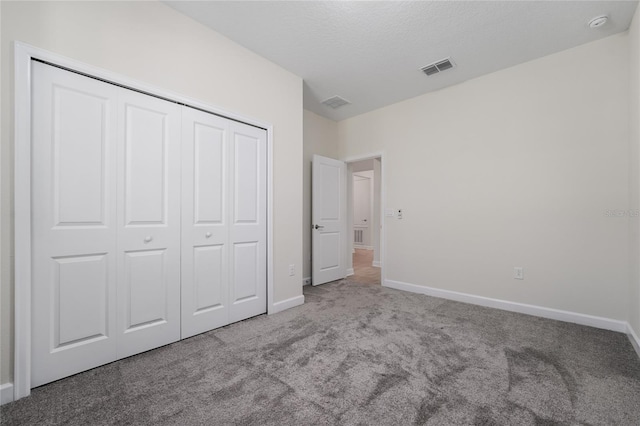 unfurnished bedroom with a closet and light colored carpet