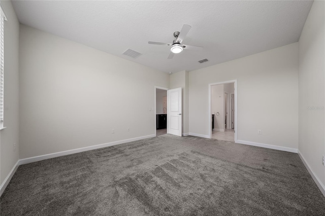 unfurnished bedroom featuring a textured ceiling, dark carpet, and ceiling fan