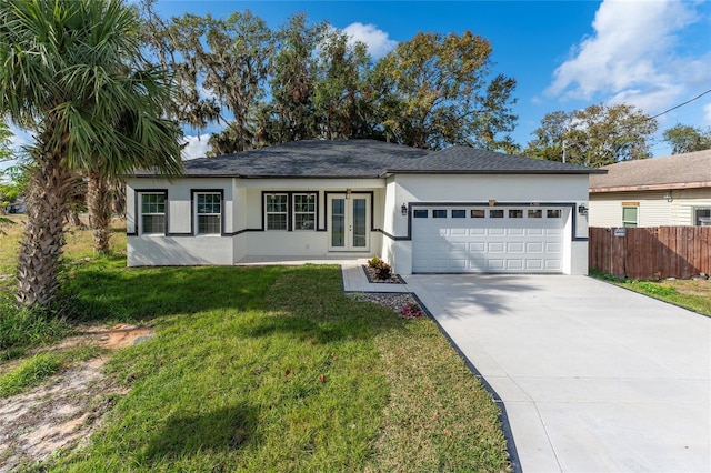 ranch-style home featuring french doors, a front yard, and a garage