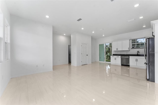 kitchen with white cabinets, light tile patterned floors, stainless steel appliances, and sink