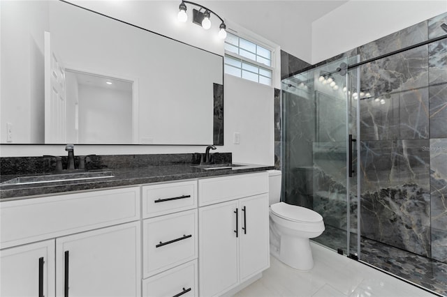 bathroom featuring vanity, a shower with shower door, and toilet