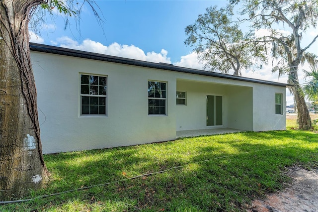 rear view of house featuring a lawn