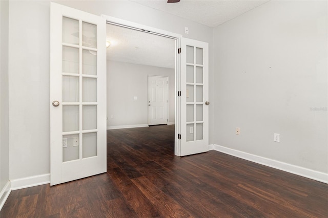 spare room featuring french doors, dark hardwood / wood-style flooring, and a textured ceiling