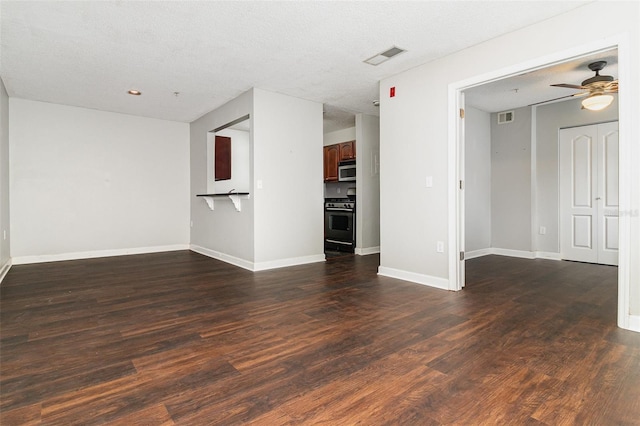 unfurnished living room with a textured ceiling, ceiling fan, and dark wood-type flooring