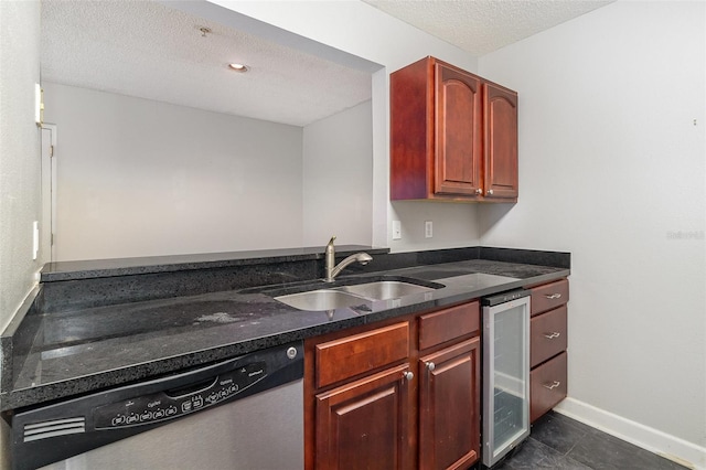 kitchen with dishwasher, sink, beverage cooler, dark tile patterned floors, and a textured ceiling