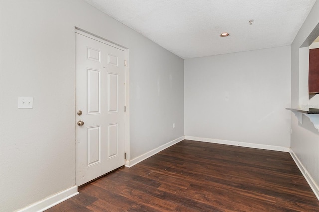 empty room featuring dark hardwood / wood-style flooring and a textured ceiling