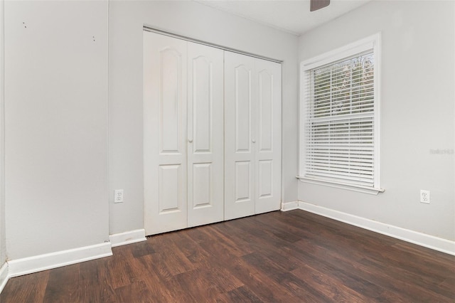 unfurnished bedroom featuring dark hardwood / wood-style floors and a closet