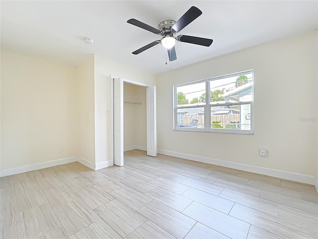 unfurnished bedroom with ceiling fan, a closet, and baseboards