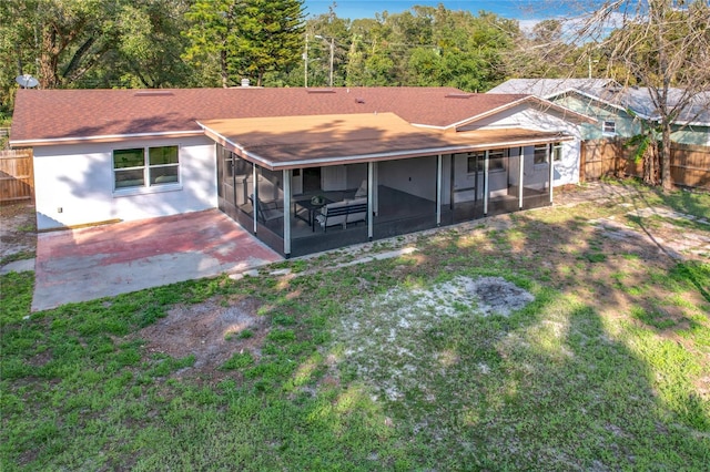 back of house featuring a sunroom, a fenced backyard, and a yard