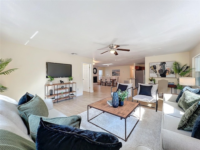 living area featuring light wood-type flooring and a ceiling fan