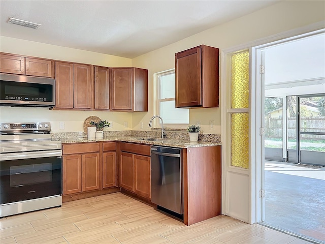 kitchen featuring appliances with stainless steel finishes, a sink, visible vents, and a healthy amount of sunlight