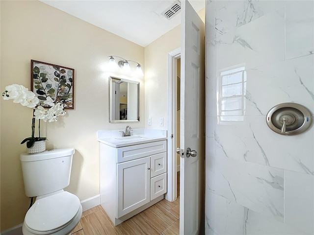 bathroom with visible vents, toilet, wood tiled floor, vanity, and baseboards