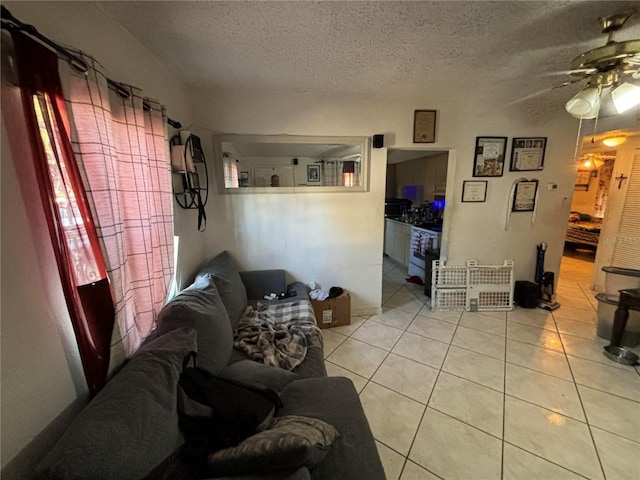 tiled living room with ceiling fan and a textured ceiling