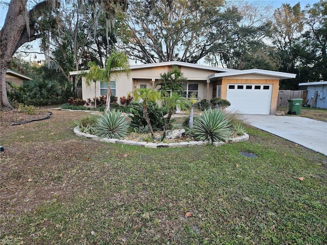 single story home featuring a garage and a front yard