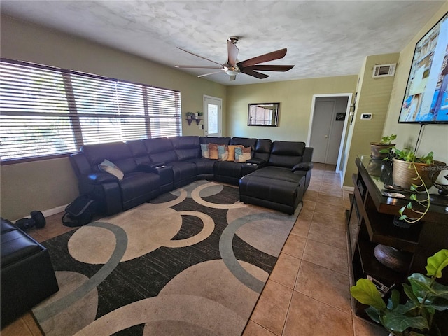 tiled living room with ceiling fan and a textured ceiling