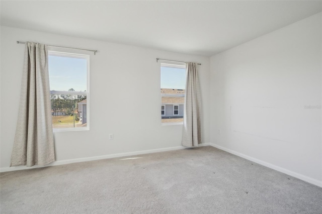 empty room with plenty of natural light and carpet flooring