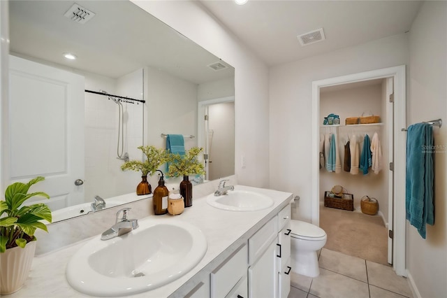 bathroom with tile patterned flooring, vanity, walk in shower, and toilet