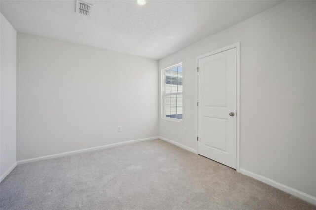 carpeted spare room featuring a textured ceiling