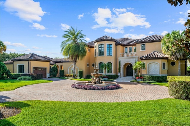 mediterranean / spanish-style home with a balcony, a front lawn, and a garage