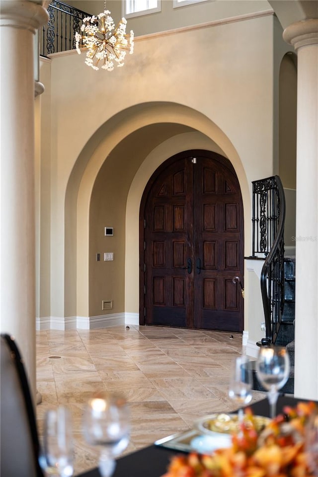 foyer featuring a towering ceiling and an inviting chandelier