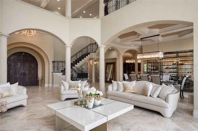 living room featuring a high ceiling, an inviting chandelier, and coffered ceiling