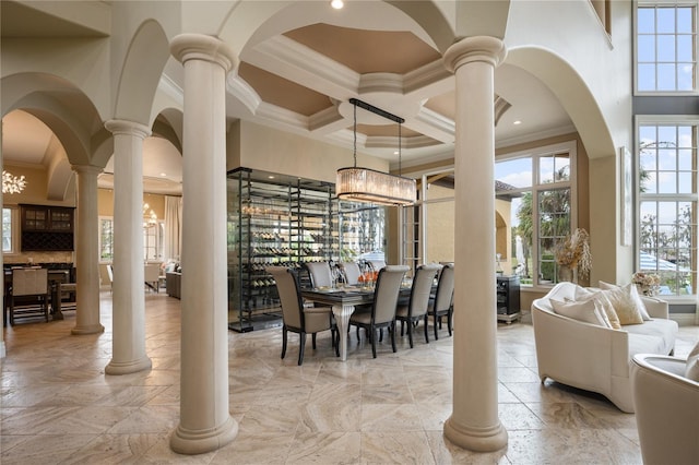 dining area featuring crown molding, a towering ceiling, coffered ceiling, and a notable chandelier