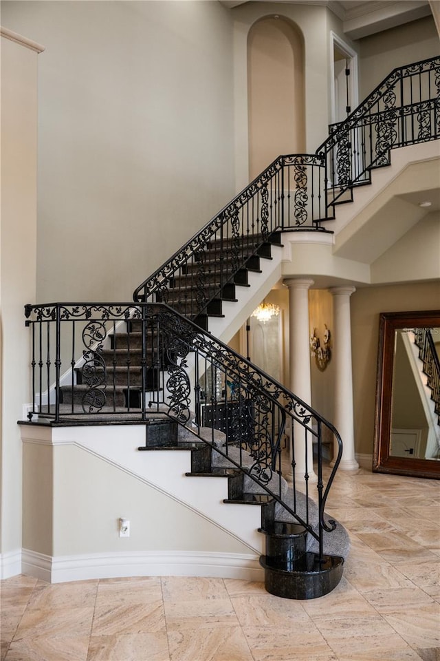 stairs featuring ornate columns and a towering ceiling