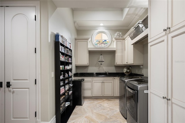 kitchen with washer and dryer, cream cabinets, ornamental molding, and sink