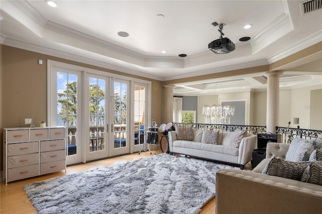 interior space featuring a raised ceiling, ornate columns, ornamental molding, and an inviting chandelier