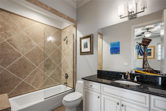 full bathroom featuring vanity, tiled shower / bath, ceiling fan, toilet, and ornamental molding