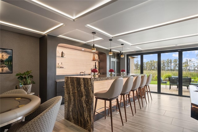 bar featuring beam ceiling, light stone countertops, coffered ceiling, a wall of windows, and pendant lighting