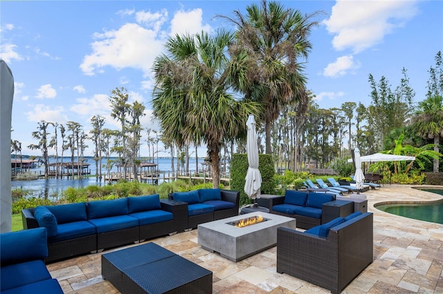 view of patio / terrace with a water view and an outdoor living space with a fire pit