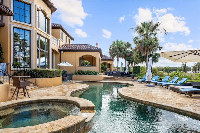 view of swimming pool featuring outdoor lounge area, a patio area, and an in ground hot tub