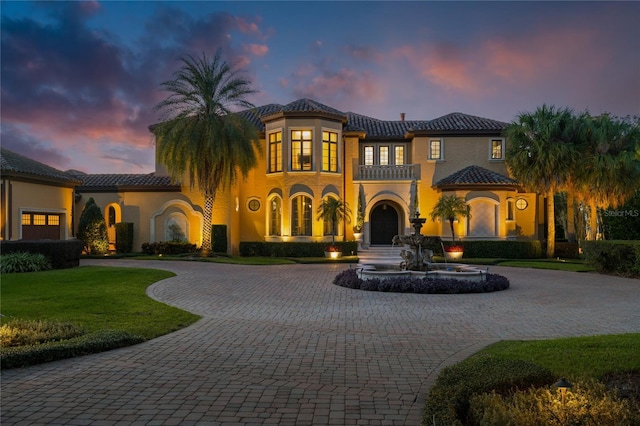 mediterranean / spanish home featuring a lawn and a balcony