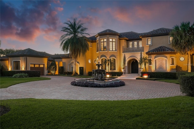 mediterranean / spanish house featuring a balcony and a lawn