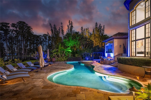 pool at dusk featuring a patio area