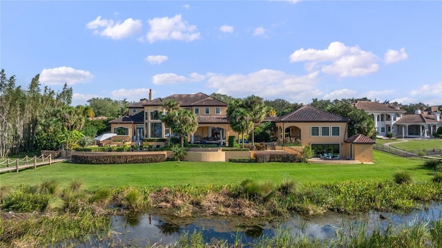 back of property featuring a yard and a water view