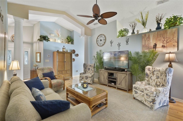 living room with light wood-type flooring, decorative columns, ceiling fan, and lofted ceiling