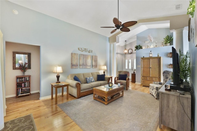 living room featuring hardwood / wood-style floors, ceiling fan, vaulted ceiling, and decorative columns