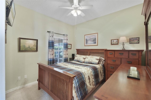 bedroom featuring ceiling fan, light colored carpet, and a textured ceiling