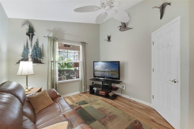 living room featuring light hardwood / wood-style flooring and ceiling fan